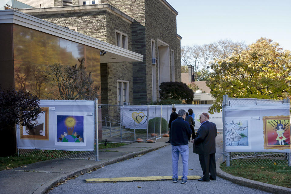 Visitors walk through the screens displaying artwork from school students surrounding the Tree of Life Synagogue Thursday, Oct. 24, 2019 in the Squirrel Hill neighborhood of Pittsburgh. Sunday, Oct. 27, marks the one-year anniversary of the deadliest attack on Jews in U.S. history. A virtual remembrance, an overseas concert and community service projects highlight the many plans for commemorating the loss. (AP Photo/Keith Srakocic)