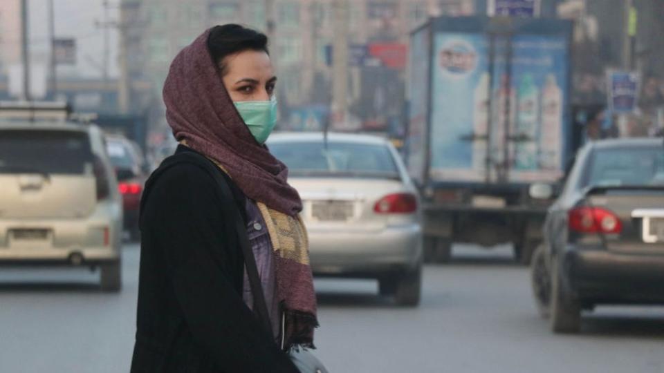 Una mujer afgana con una mascarilla camina en el bazar de Kabul, Afganistán, 23 de diciembre de 2020