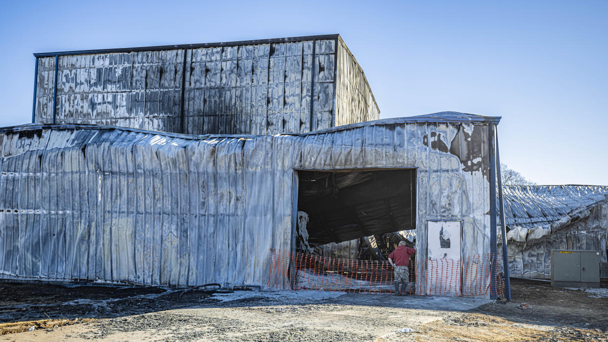 A Premier Wax employee observes the destruction caused by the fire that engulfed a large portion of the factory, 200 South A St., Ochelata, on Friday.