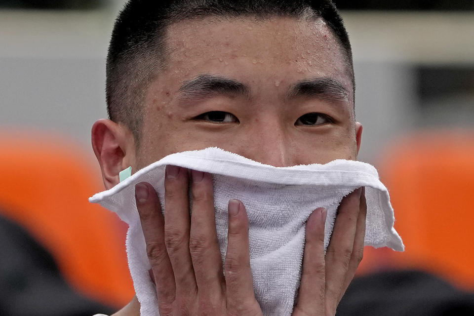 Shiyan Gao, from China, wipes away sweat during practice for the 3-on-3 basketball competition at the 2020 Summer Olympics, Wednesday, July 21, 2021, at the Aomi Urban Sports Park in Tokyo. (AP Photo/Charlie Riedel)