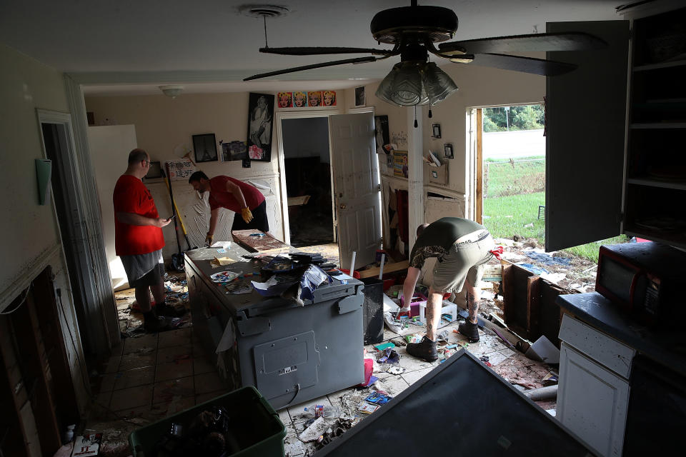 Bryan Parson (left), Chris Gaspard (center) and Derek Pelt (right) remove ruined items from Parson's home.