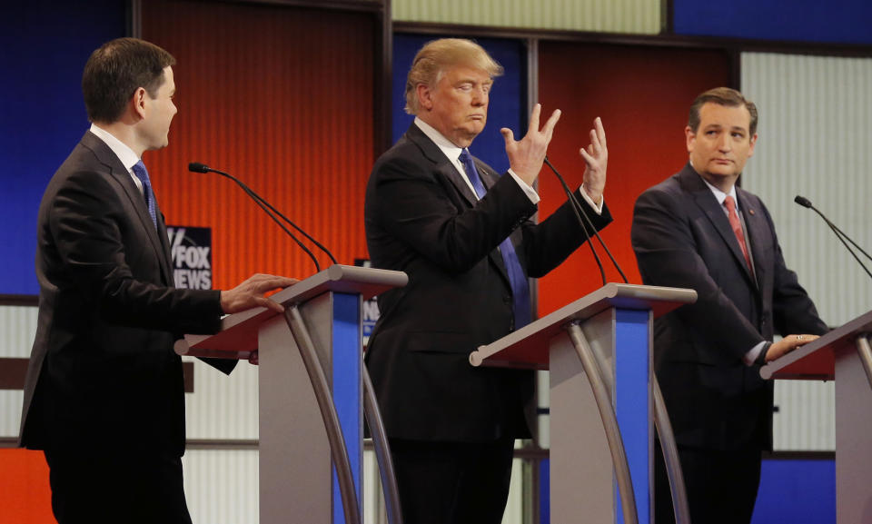 Republican U.S. presidential candidate Donald Trump shows off the size of his hands as rivals Marco Rubio (L) and Ted Cruz (R) look on at the start of the U.S. Republican presidential candidates debate in Detroit, Michigan, March 3, 2016. REUTERS/Jim Young 