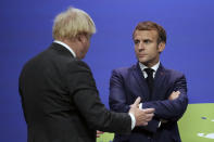 British Prime Minister Boris Johnson, left, talks to French President Emmanuel Macron, at the COP26 U.N. Climate Summit in Glasgow, Scotland, Monday, Nov. 1, 2021. The U.N. climate summit in Glasgow gathers leaders from around the world, in Scotland's biggest city, to lay out their vision for addressing the common challenge of global warming. (Christopher Furlong/Pool via AP)