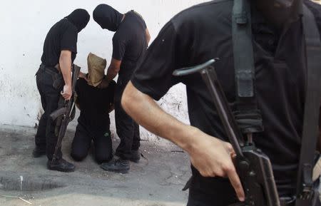 Hamas militants grab a Palestinian suspected of collaborating with Israel before being executed in Gaza City August 22, 2014. REUTERS/Stringer