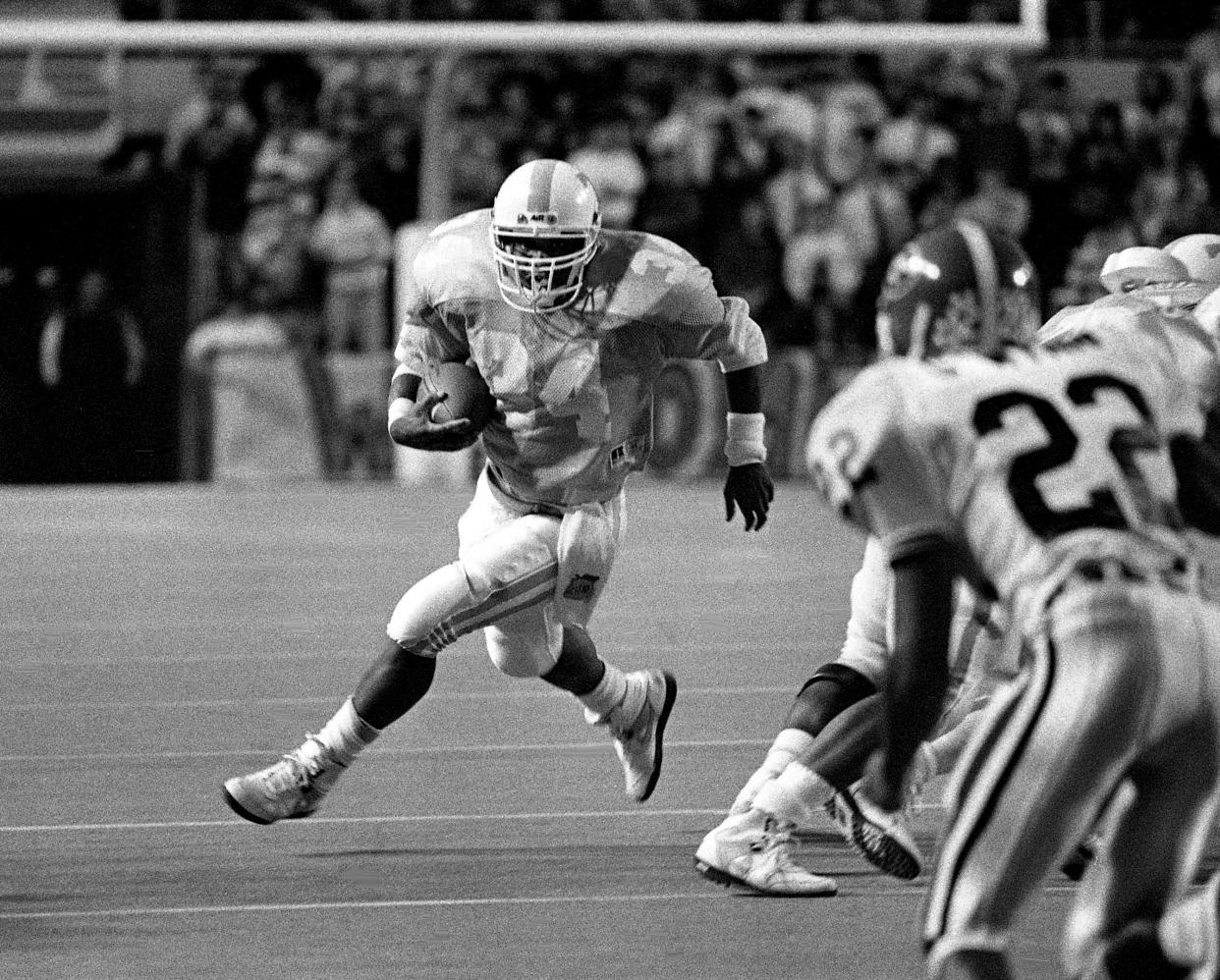 Tennessee running back Reggie Cobb (34), who rushed for 106 yards and scored a touchdown, heads upfield toward Georgia cornerback George Wynn (22) in the first half. Sixth-ranked Tennessee survived with a 17-14 victory before 96,058 fans at Neyland Stadium on Oct. 7, 1989.