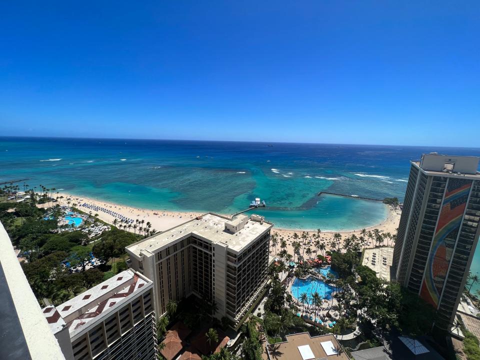 A view of the beach in front of Hilton's Hawaiian Village Waikiki Beach Resort, as seen from a balcony.