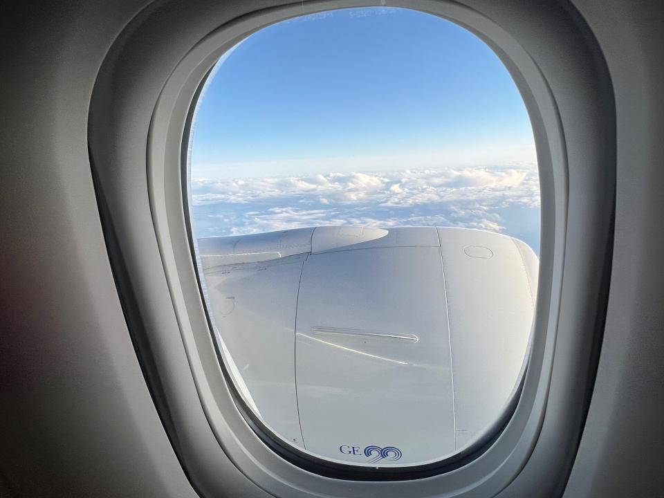 A view outside the plane window with clouds in distance.