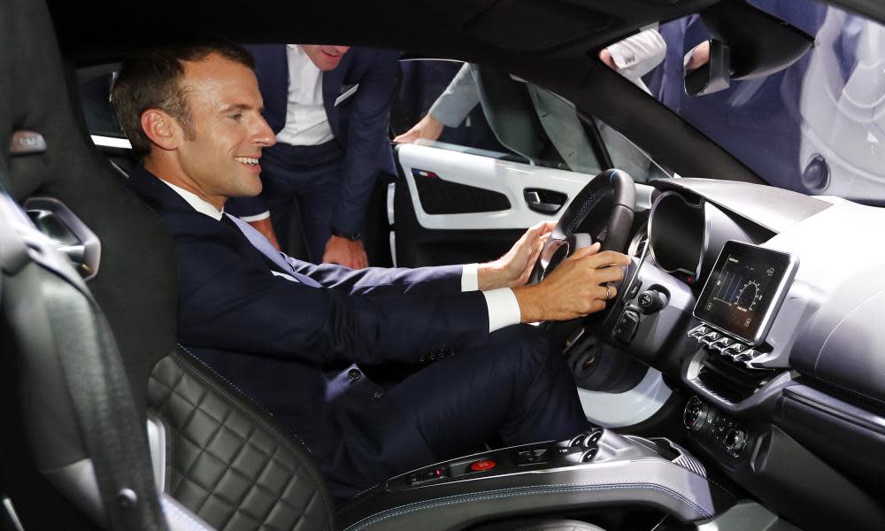President Emmanuel Macron sits inside an Alpine car during a visit to the Paris motor show on 3 October.