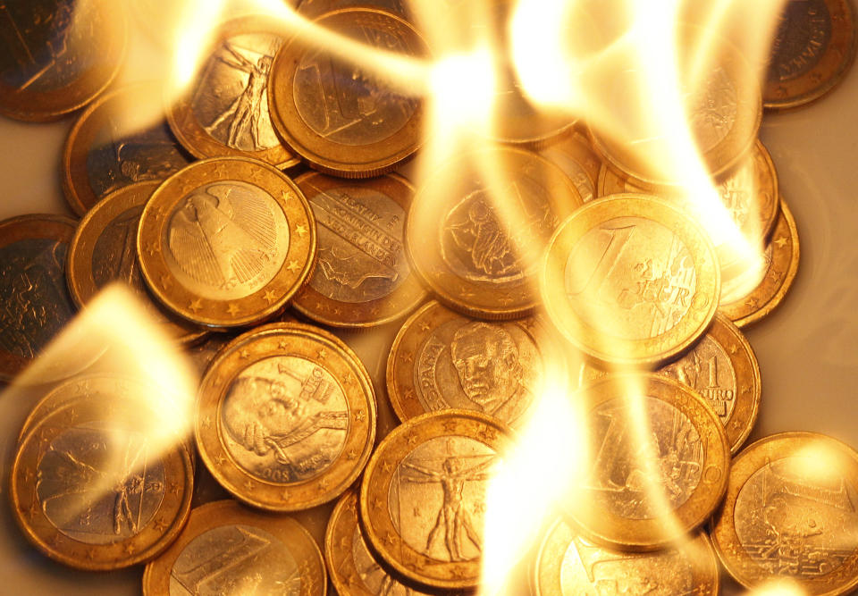 Several one euro coins are pictured in flames in this illustration photo taken in Vienna on July 19, 2011. (REUTERS/Lisi Niesner)