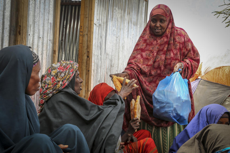 FILE - Somalis who fled drought-stricken areas receive charitable food donations from city residents after arriving at a makeshift camp for the displaced on the outskirts of Mogadishu, Somalia on June 30, 2022. Food prices accounted for about 60% of last year’s increase in headline inflation in the Middle East and North Africa, with the exception of oil-producing Gulf countries. In Somalia, where 2.7 million people cannot meet their daily food requirements and where children are dying of famine, sugar is a source of energy and fuel. In May, a kilogram (2.2 pounds) of sugar cost around the equivalent of 72 cents in the capital, Mogadishu. (AP Photo/Farah Abdi Warsameh, File)