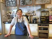 Caroline Atkinson, owner of the Rose Coffee House poses for a photo as she prepares to reopen, in Belmont, Durham, England, Thursday May 13, 2021. Travelers are packing their bags, café-owners are polishing their cutlery and stage performers are warming up as Britain prepared for a major step out of lockdown. But excitement at the reopening of travel and hospitality vied with anxiety about a more contagious variant spreading in the country (Tom Wilkinson/PA via AP)