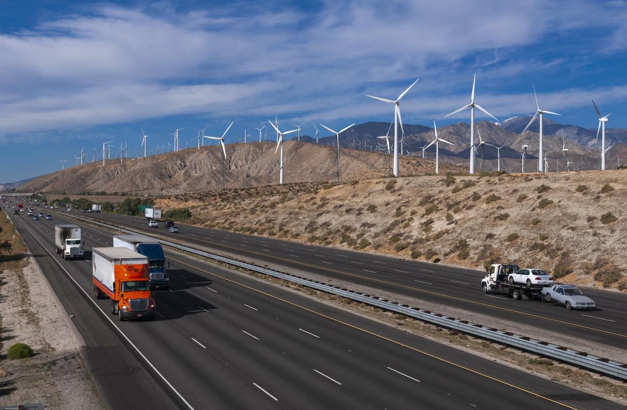 Electrifying trucks and cars and shifting to renewable energy are crucial for California's zero-emissions future. <a href="https://www.gettyimages.com/detail/news-photo/traffic-passes-a-wind-farm-in-the-san-gorgonio-pass-near-news-photo/1371863246" rel="nofollow noopener" target="_blank" data-ylk="slk:Sergio Pitamitz / VWPics/Universal Images Group via Getty Images;elm:context_link;itc:0;sec:content-canvas" class="link ">Sergio Pitamitz / VWPics/Universal Images Group via Getty Images</a>