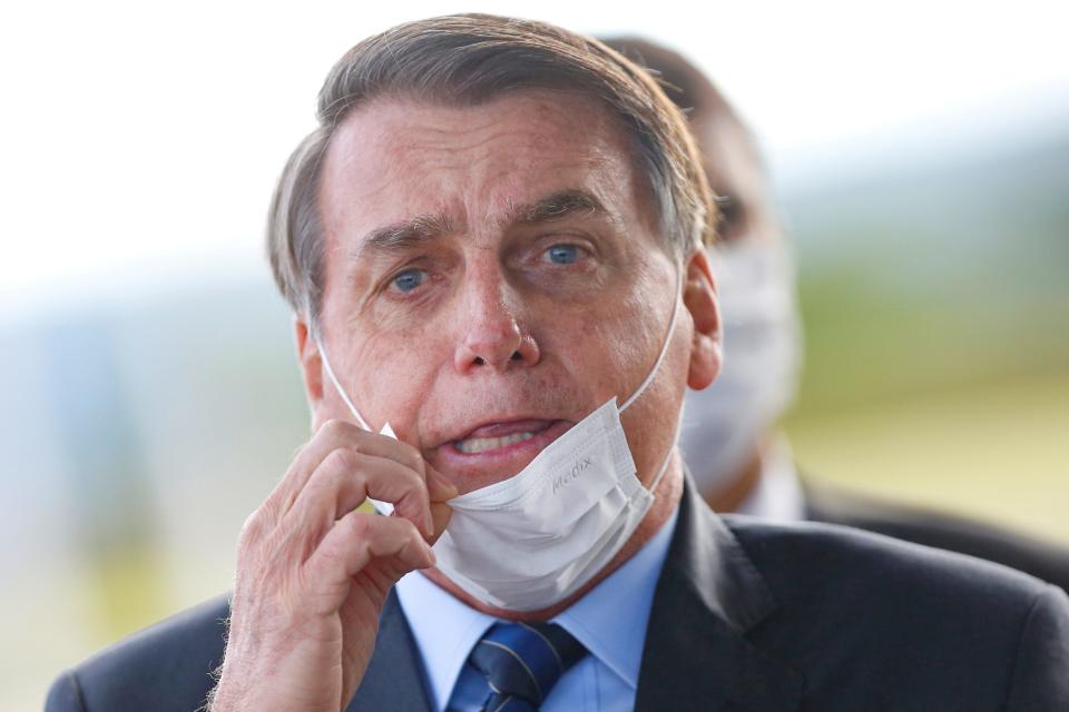 FILE PHOTO: Brazil's President Jair Bolsonaro adjusts his mask as he leaves Alvorada Palace, amid the coronavirus disease (COVID-19) outbreak in Brasilia, Brazil May 13, 2020. REUTERS/Adriano Machado TPX IMAGES OF THE DAY/File Photo