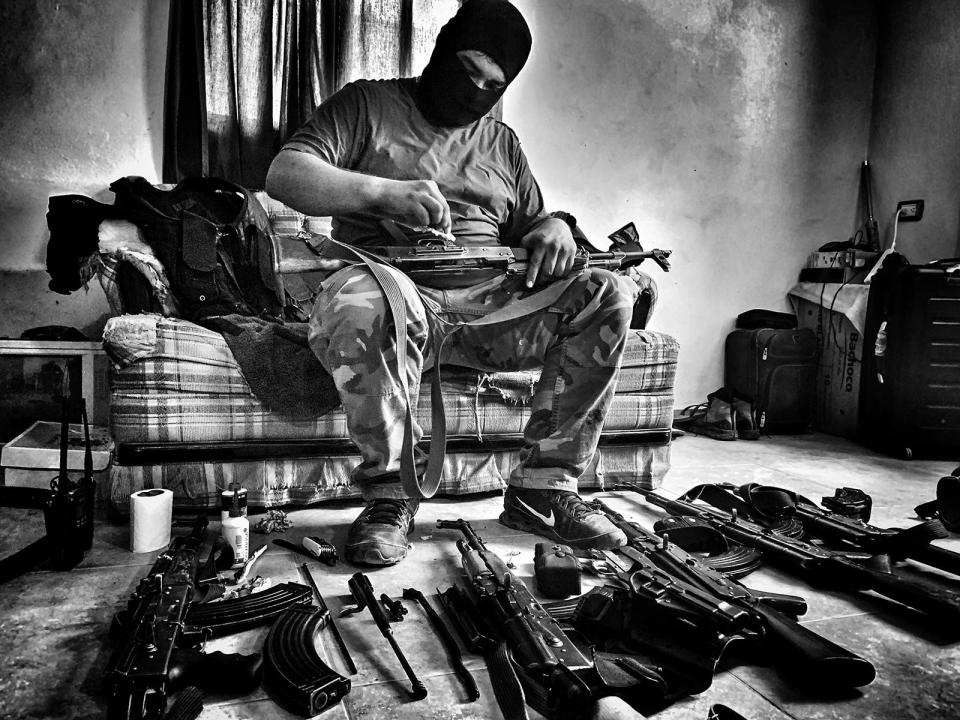 A soldier from the Sinaloa drug cartel cleans guns in the National Geographic documentary on migration "Blood on the Wall."