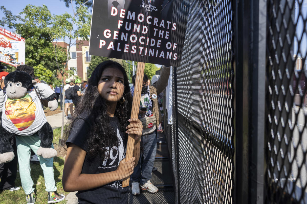 A pro-Palestinian demonstrator holds a sign reading: Democrats fund the genocide of Palestinians.