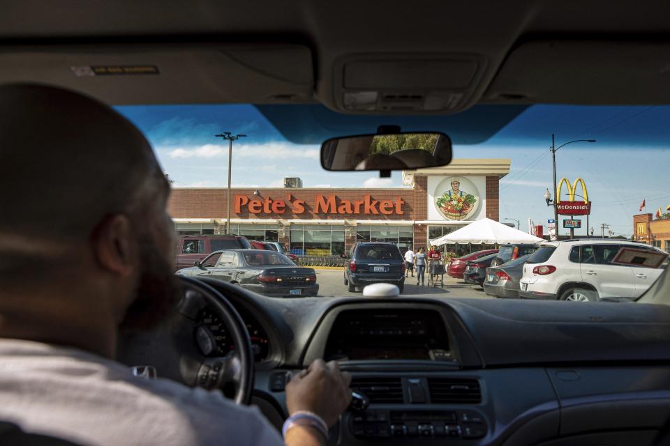 In this Thursday, Aug.15, 2019, photo, Christopher "Mad Dog" Thomas, drives into Pete's Market in Chicago's Garfield Neighborhood. Thomas organizes a weekly family trip outside their neighborhood to the store, which his wife describes as "the black or Hispanic Whole Foods." (AP Photo/Amr Alfiky)