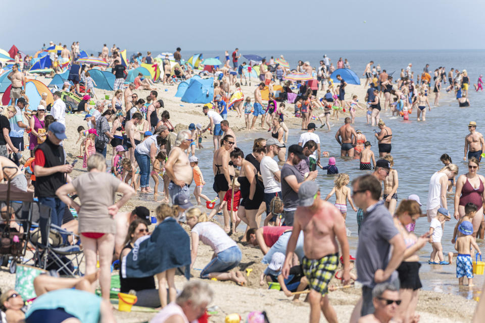 Numerous beach visitors are at summery temperatures on the North Sea beach of Schillig, Germany, Saturday, July 18, 2020. (Mohssen Assanimoghaddam/dpa via AP)