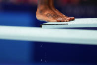 A tattoo of the Olympic rings decorate the foot of Jennifer Abel, of Canada, as she prepares to dive in the women's diving 3-meter springboard preliminary at the 2020 Summer Olympics, Friday, July 30, 2021, in Tokyo. (AP Photo/David Goldman)