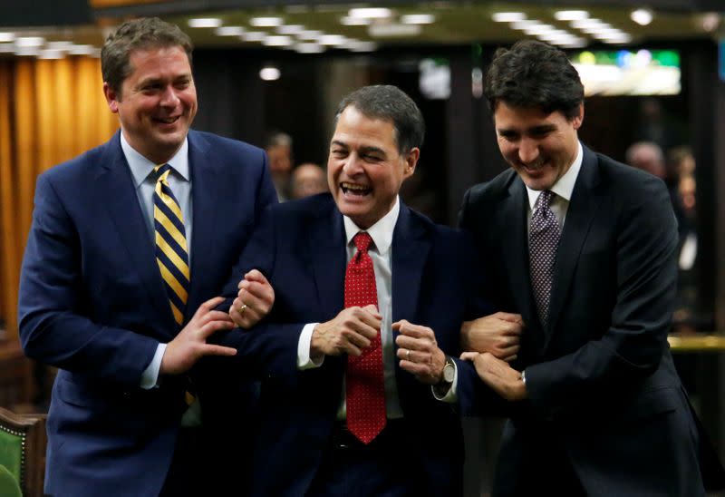 Liberal Ontario MP Anthony Rota is dragged to the Speakers chair by Canada's Prime Minister Justin Trudeau, right, and Conservative Party leader and Leader of the Official Opposition Andrew Scheer in Ottawa