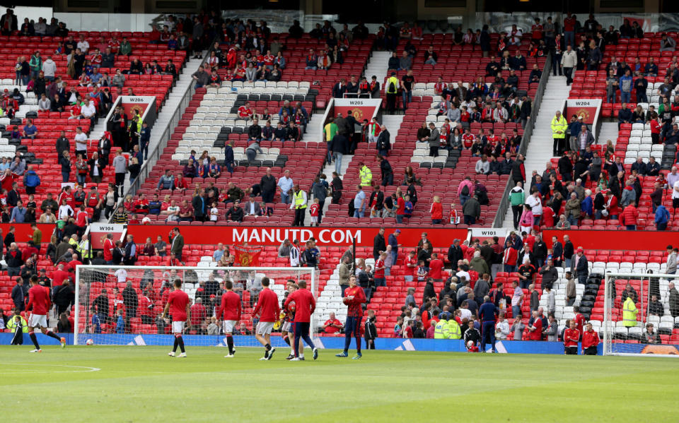 Fans and players leave the pitch and Stretford End stand after an announcement to evacuate before the English Premier League match at Old Trafford in Manchester, England, on May 15, 2016. (Martin Rickett/PA via AP)