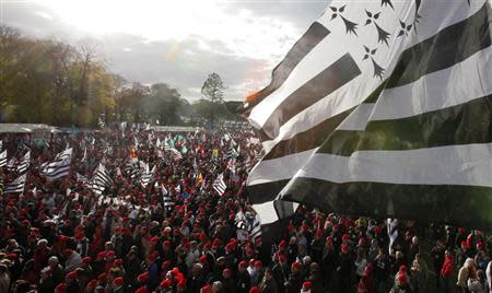 Protesters wearing red caps, the symbol of protest in Brittany and waving Breton regional flags, take part in a demonstation to maintain jobs in the region and against an "ecotax" on commercial trucks, in Carhaix, western France, November 30, 2013. REUTERS/Mal Langsdon