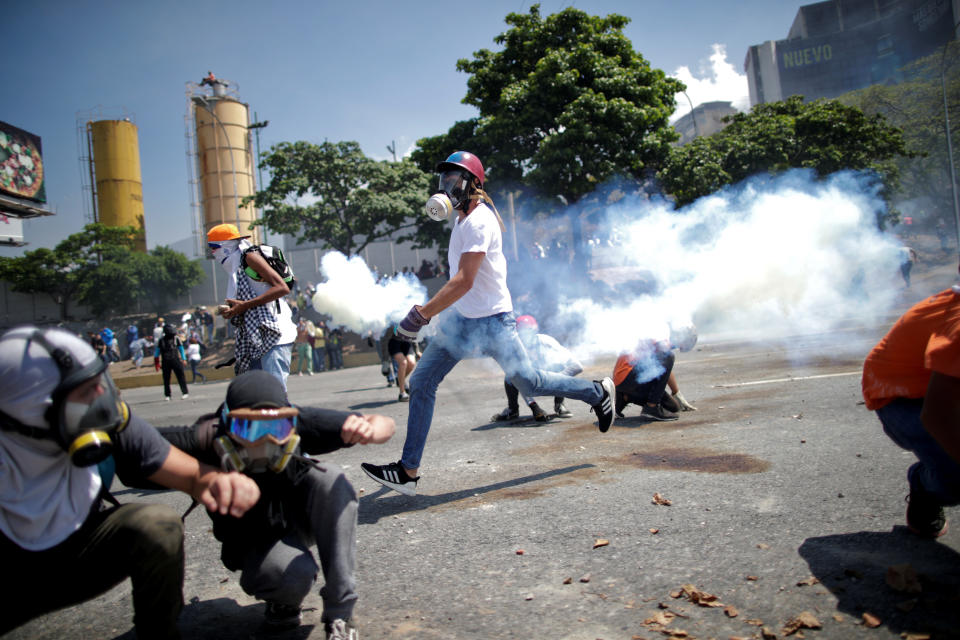 Opposition demonstrators take cover from tear gas on a street near the Generalisimo Francisco de Miranda Airbase "La Carlota" in Caracas, Venezuela April 30, 2019. (Photo: Ueslei Marcelino/Reuters)