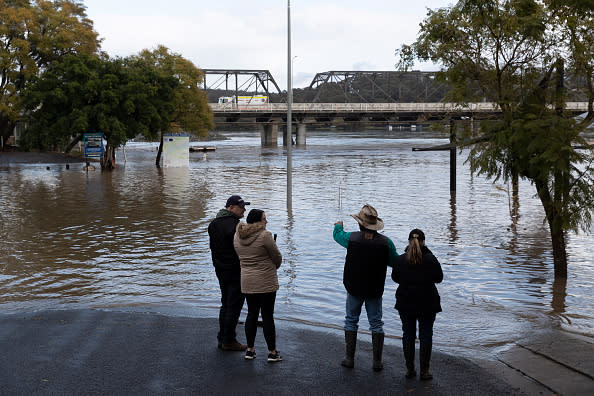 People look on as heavy flooding is seen along the Shoalhaven River in Nowra.