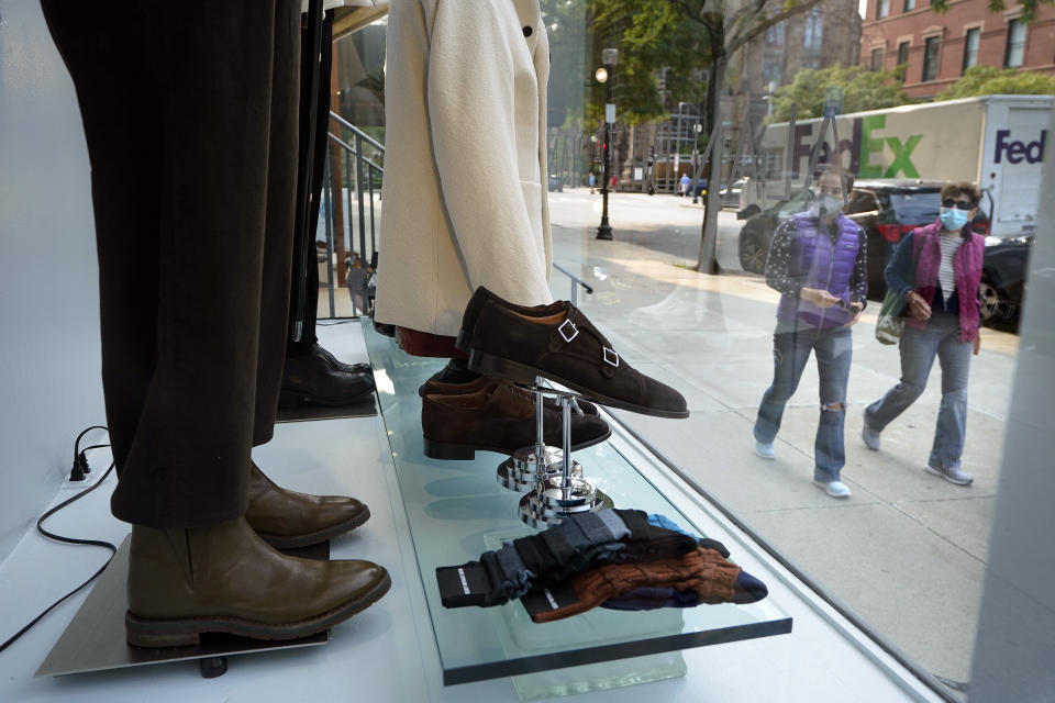 FILE - In this Sept. 15, 2020, file photo, people examine a storefront window as they walk in Boston's fashionable Newbury Street shopping district. Defying fears of another slowdown, U.S. businesses kept hiring at a solid pace in October yet there are signs they remain cautious about the economy's future as the pandemic worsens. (AP Photo/Steven Senne, File)