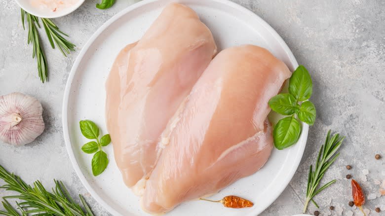 raw chicken breasts on plate