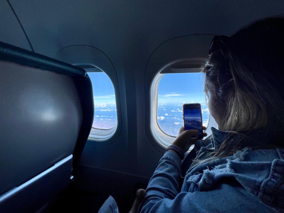 Passenger taking picture of aerial view of Hawaii outside plane window