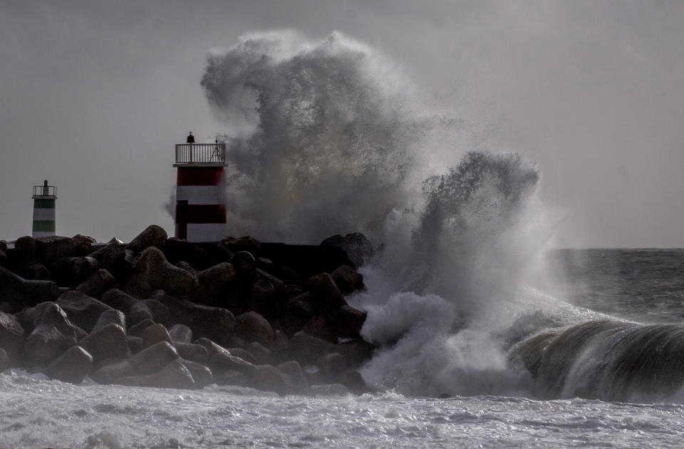 Big waves crash against a light house in Nazare, Portugal, Wednesday, March 27, 2024. Strong winds caused the high waves in one of the world's most popular surf spots. (AP Photo/Michael Probst)