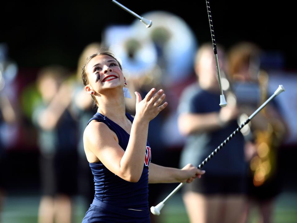 A Halls High School majorette performs with three batons during the pregame show for the high school football game against Campbell County in Knoxville, Tenn. on Thursday, August 17, 2023.