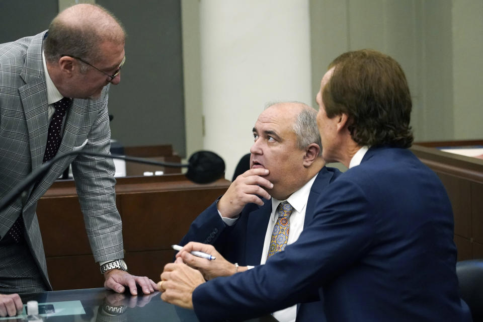 John Davis, former director of the Mississippi Department of Human Services confers with defense attorneys Merrida Coxwell, right, and Charles Mullins, left, in Jackson, Miss., on Thursday, Sept. 22, 2022. Davis pleaded guilty to new federal charges in a conspiracy to misspend tens of millions of dollars that were intended to help needy families in one of the poorest states in the U.S. — part of the largest public corruption case in the state's history.(AP Photo/Rogelio V. Solis)