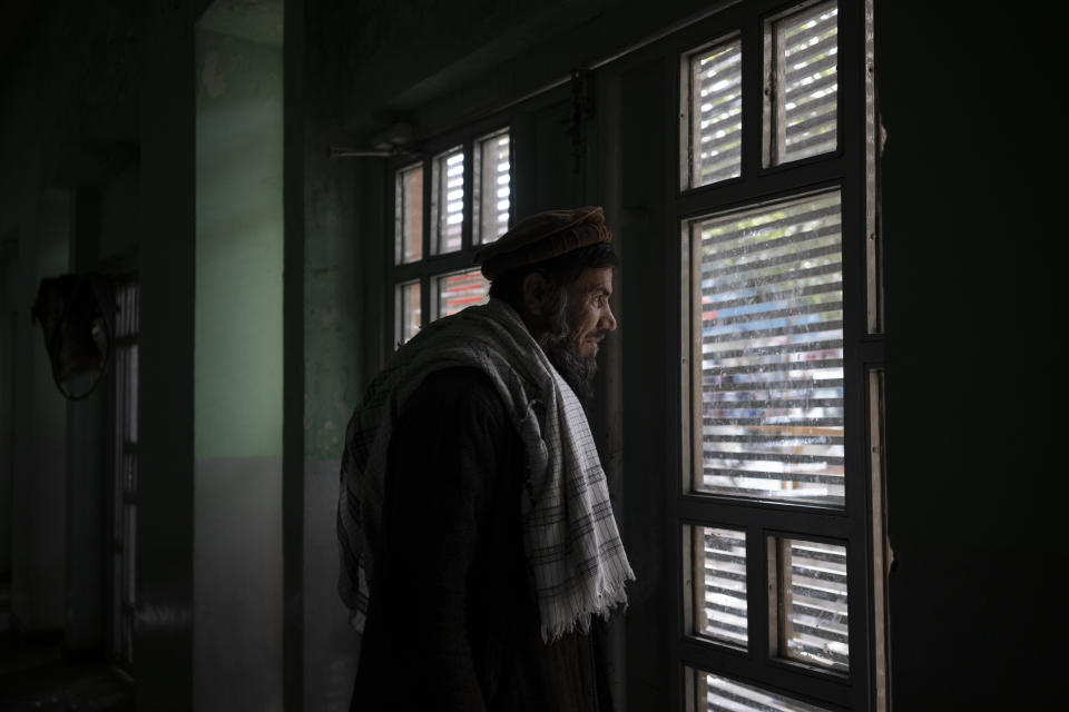 Abdul Fatah looks out the window from the Ariana Cinema in Kabul, Afghanistan, Sunday, Oct. 31, 2021. Fatah lives in the cinema where he works as a security guard. (AP Photo/Bram Janssen)