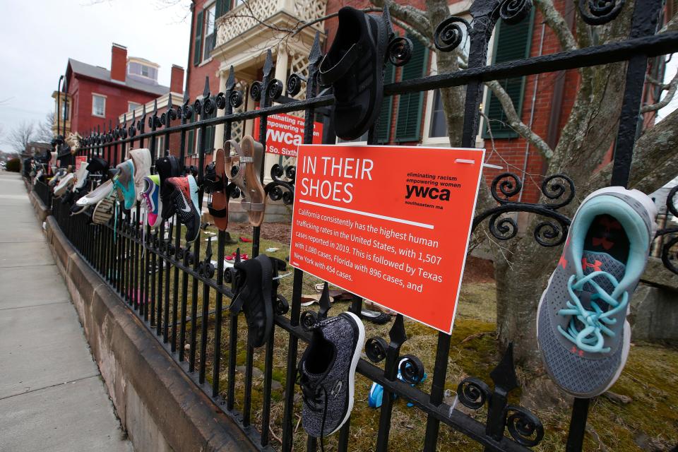 Shoes hang on the fence in front of the YWCA on S. 6th Street in New Bedford where a discussion on human trafficking called "In Their Shoes" was held Jan. 26.