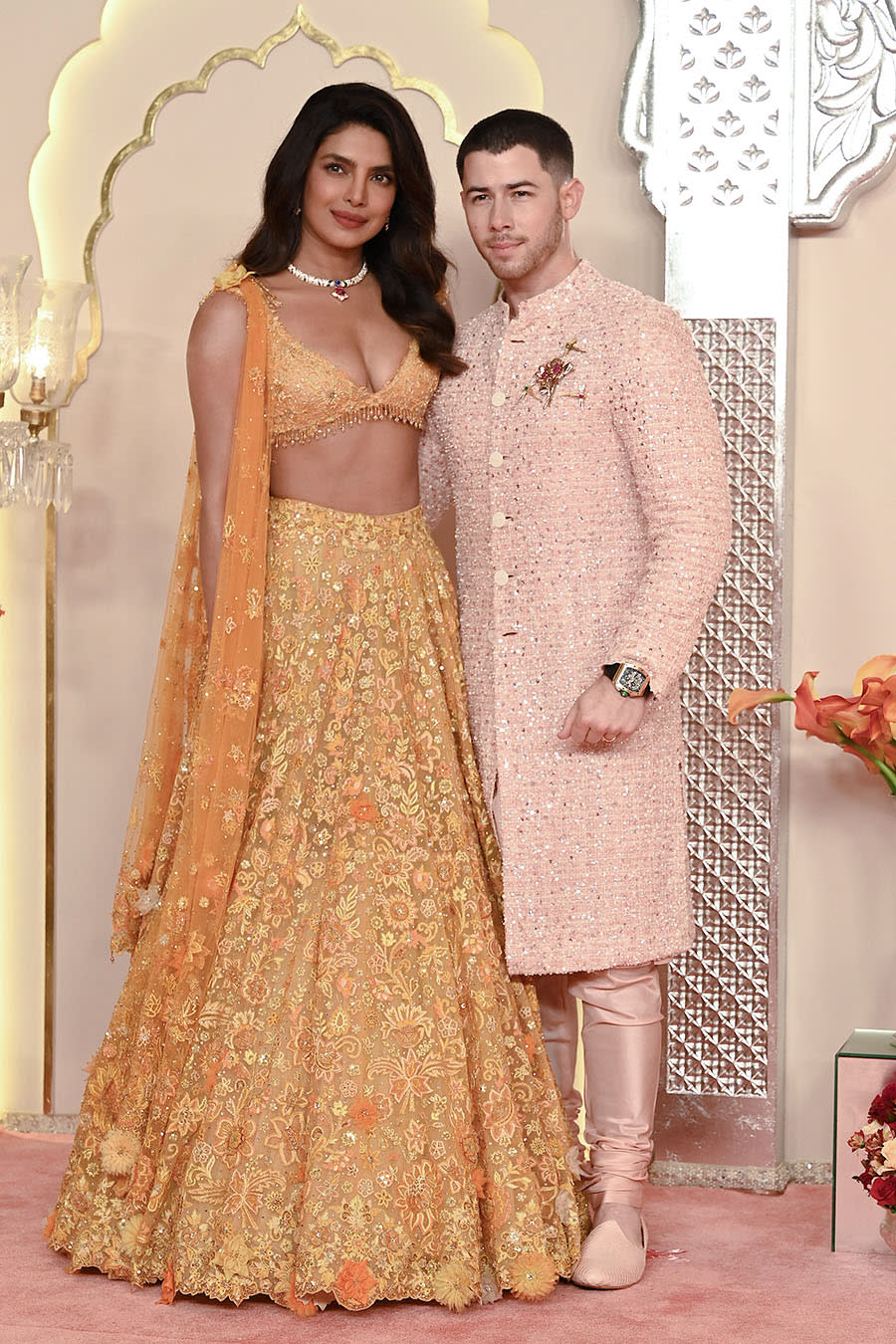 Indian actress Priyanka Chopra Jonas (L) and her husband American singer-songwriter and actor Nick Jonas (R) pose for photos as they arrive to attend the wedding ceremony of billionaire tycoon and Chairman of Reliance Industries Mukesh Ambani's son Anant Ambani and Radhika Merchant in Mumbai on July 12, 2024. Socialite sisters Kim and Khloe Kardashian were among the global celebrities spotted in India on July 12 to attend a lavish three-day wedding ceremony staged by Asia's richest man Mukesh Ambani. (Photo by SUJIT JAISWAL / AFP) (Photo by SUJIT JAISWAL/AFP via Getty Images)