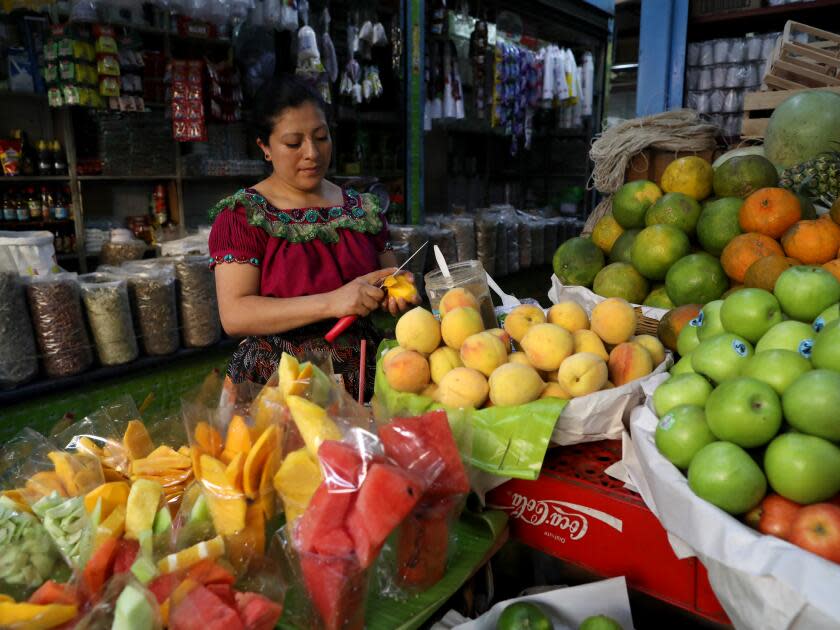 Anabella Juarez prepares cut mango in the Central Market in Guatemala City.