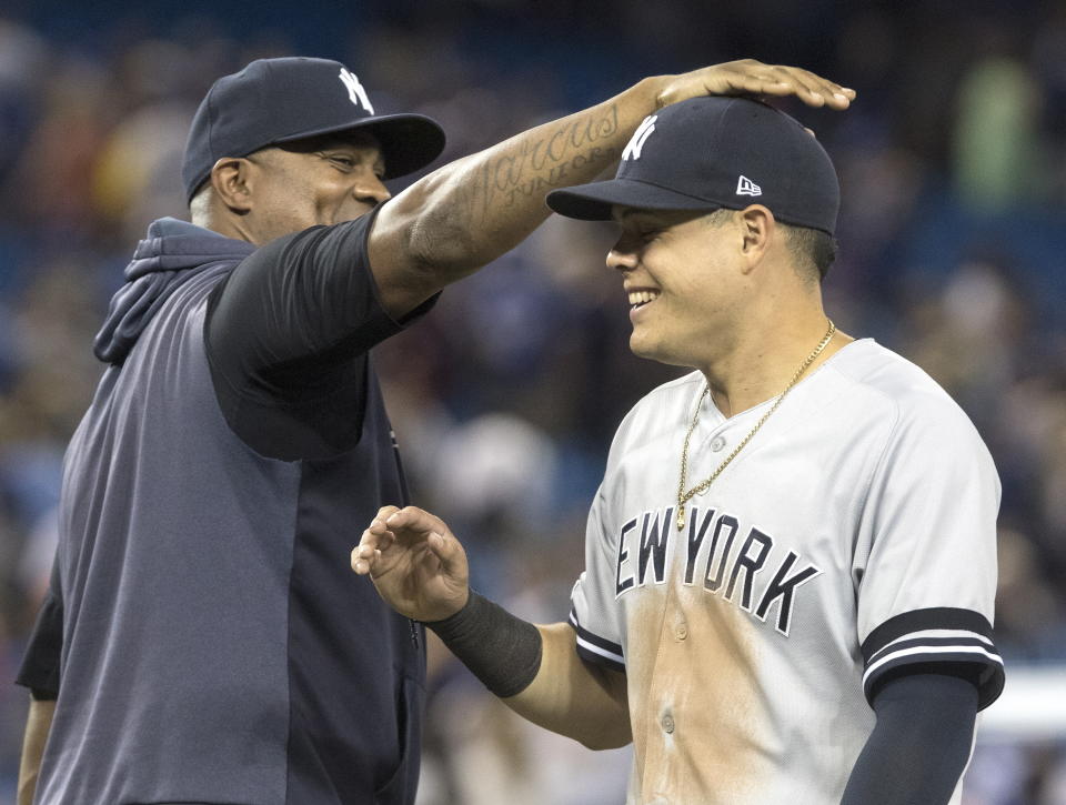 New York Yankees' Gio Urshela celebrates with C.C. Sabathia after the Yankees defeated the Toronto Blue Jays 12-6 in a baseball game Thursday, Aug. 8, 2019, in Toronto. (Fred Thornhill/The Canadian Press via AP)