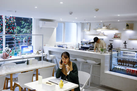 A woman sits in a boutique that doubles as cafe in the E-Cool centre in a building of the former Sanyo factory in the Shekou area of Shenzhen, Guangdong Province, China, December 14, 2018. Picture taken December 14, 2018. REUTERS/Thomas Peter