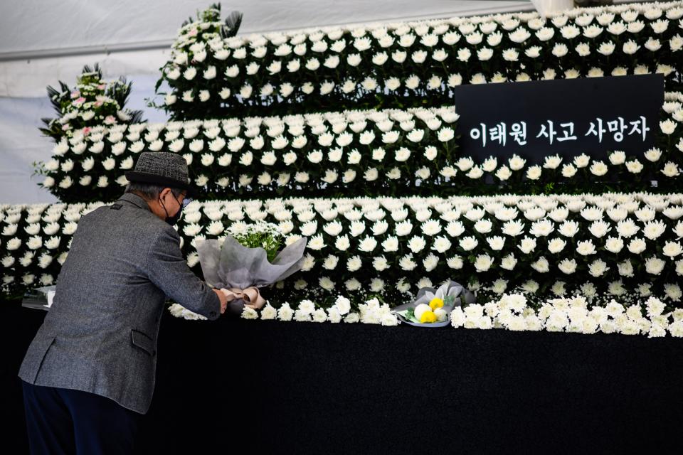 A man offers a flower at a joint memorial altar for victims of the deadly Halloween crowd surge, in Naksopyeong, near the district of Itaewon in Seoul on October 31, 2022. (Photo by ANTHONY WALLACE / AFP) (Photo by ANTHONY WALLACE/AFP via Getty Images)