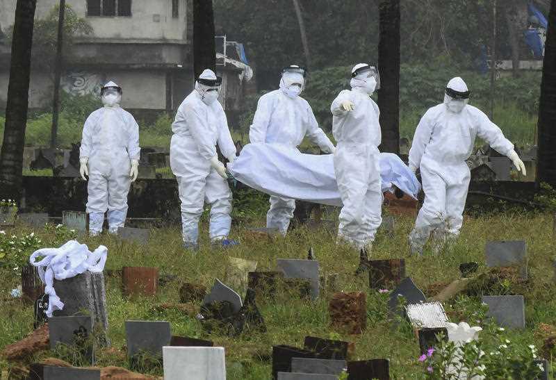 People in protective suits prepare to cremate the body of a 12-year-old boy died of the Nipah virus in Kozhikode, Kerala state, India.