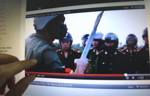 A man watches a video posted on the blog of Dr. Nguyen Xuan Dien showing villagers challenging policemen during forced land evictions in Van Giang district in April 2012. Some activists and experts say the government is fighting a losing battle to police Vietnam's 30 million plus online community