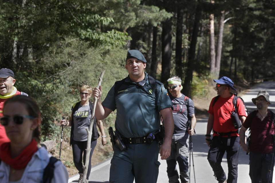 A civil guard leads volunteers searching in woodland area in Cercedilla, just outside of Madrid, Spain, Tuesday, Sept. 3, 2019. A search squad of hundreds is combing a mountainous area outside Madrid 11 days after former alpine ski racer and Olympic medalist Blanca Fernandez Ochoa went missing.(AP Photo/Paul White)