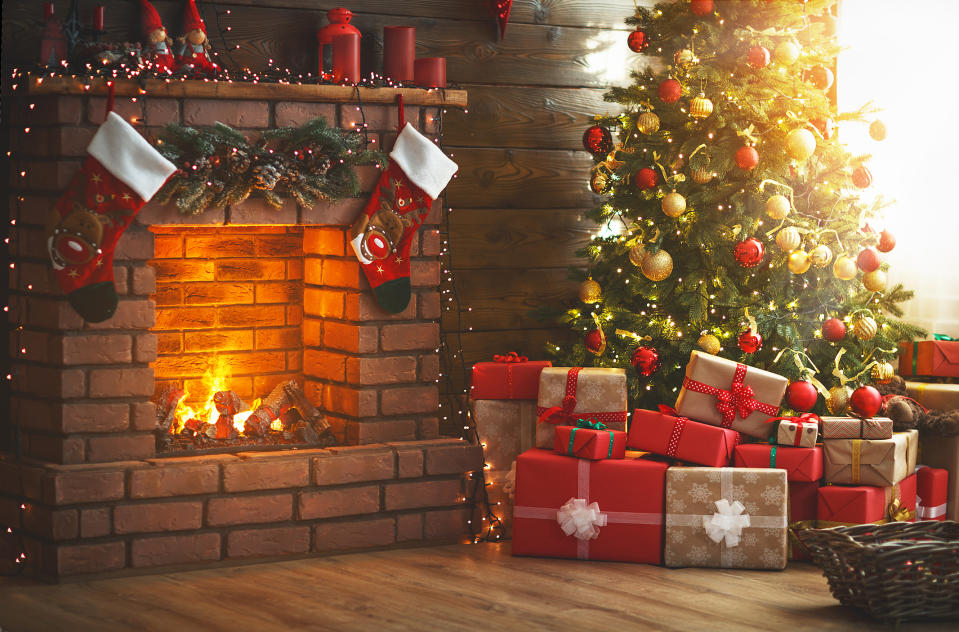 Presents under a Christmas tree by a fire