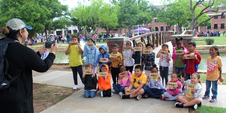Teacher Herminia Cano takes a photo of her Martinez Elementary School kindergarten class after they watched a branding demonstration.