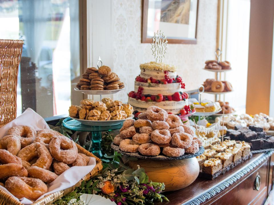 Dessert table at a wedding with doughnuts and a cake