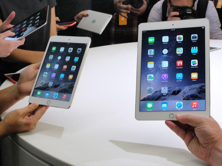 People look at the new  iPad Mini 3 (L) and iPad Air 2 (R) on October 16, 2014 during an event unveiling the company's new iPad line in Cupertino