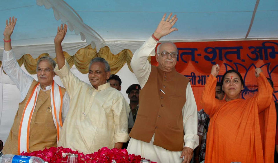 FILE - In this July 28, 2005 file photo, Indian opposition leader and President of the Bharatiya Janta Party (BJP) L.K. Advani, second right, senior BJP leaders Uma Bharati, right, Kalyan Singh, second left, and Murli Manohar Joshi wave during a public rally in Rae Bareilly, in the northern Indian state of Uttar Pradesh. An Indian court on Wednesday, Sept. 30, 2020, acquitted all 32 people who had been accused of crimes in a 1992 attack and demolition of a 16th century mosque that sparked Hindu-Muslim violence leaving some 2,000 people dead. The four senior leaders of the ruling Hindu nationalist Bharatiya Janata Party had been among the defendants at the trial that languished in India’s sluggish legal system for almost 28 years. (AP Photo/Rajesh Kumar Singh, File)