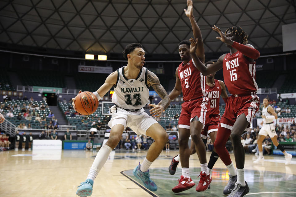 Hawaii guard Samuta Avea (32) tries to get past Washington State guard TJ Bamba (5) and center Adrame Diongue (15) during the second half of an NCAA college basketball game, Friday, Dec. 23, 2022, in Honolulu. (AP Photo/Marco Garcia)