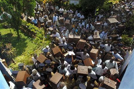 Polling officers carrying ballot boxes walk with police officers as they prepare to go to their polling centres ahead of first provincial polls in 25 years in Jaffna, a former war zone in northern Sri Lanka, about 400 kilometres (249 miles) north of Colombo September 20, 2013. REUTERS/Dinuka Liyanawatte